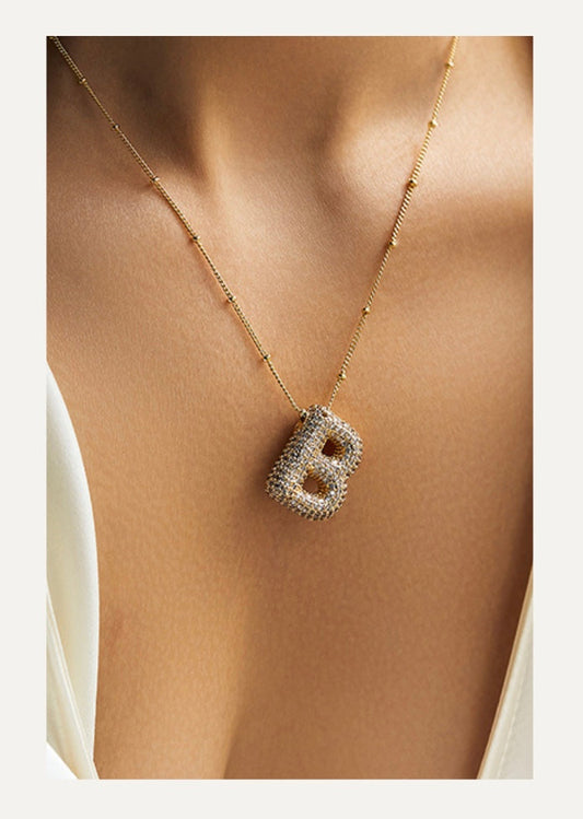 Model draagt Stella Initial Spark ketting – zilveren schakelketting met fonkelende initial‑hanger bezet met kristalstenen | Becker’s Amsterdam