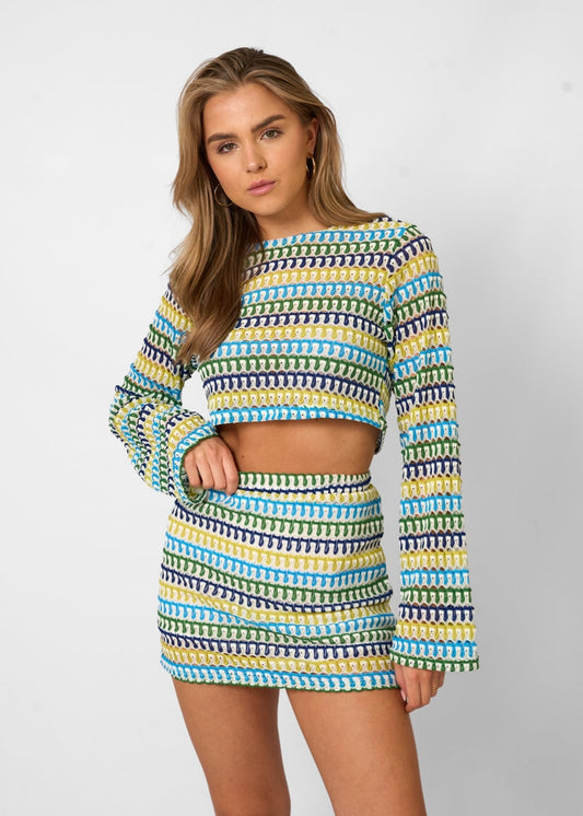 Model draagt Mara cropped top met lange mouwen en high‑waist mini rok in gebreide slim fit set | Becker’s Amsterdam