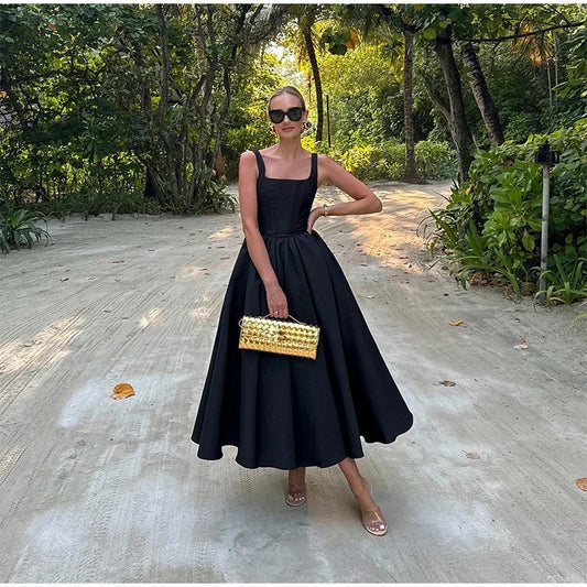 Model draagt Isabel Square Midi Dress – mouwloze midi-jurk met vierkante hals, elastische taille en A‑lijn silhouet | Becker’s Amsterdam